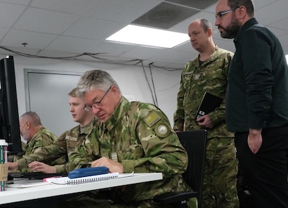 US and New Zealand military members work on computers