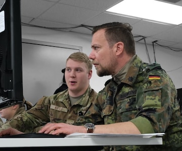 uniformed military members work on computers