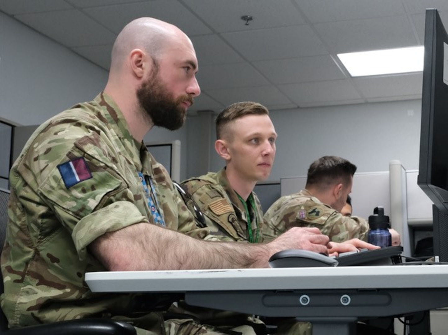 uniformed military members work on computers