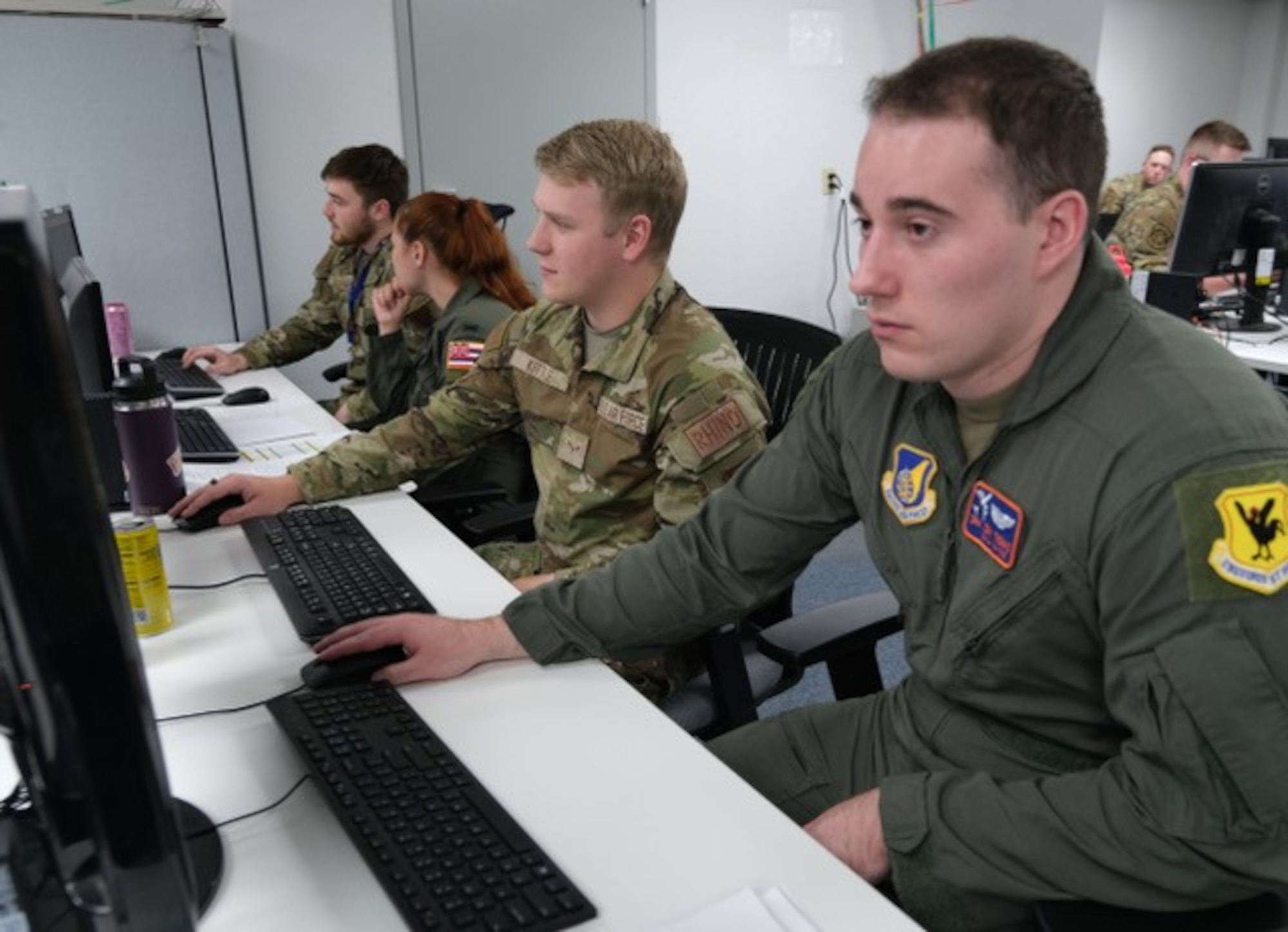 uniformed military members work on computers