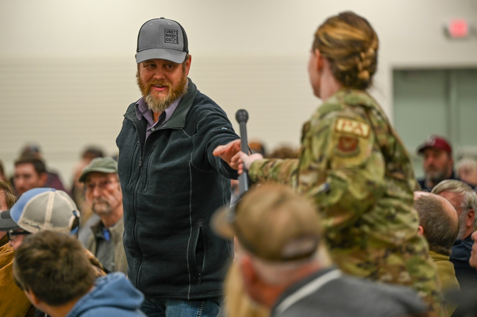 A woman hands a microphone to a man.