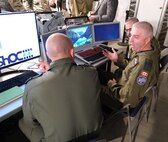 uniformed military members work on computers