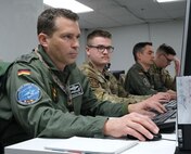 uniformed military members work on computers