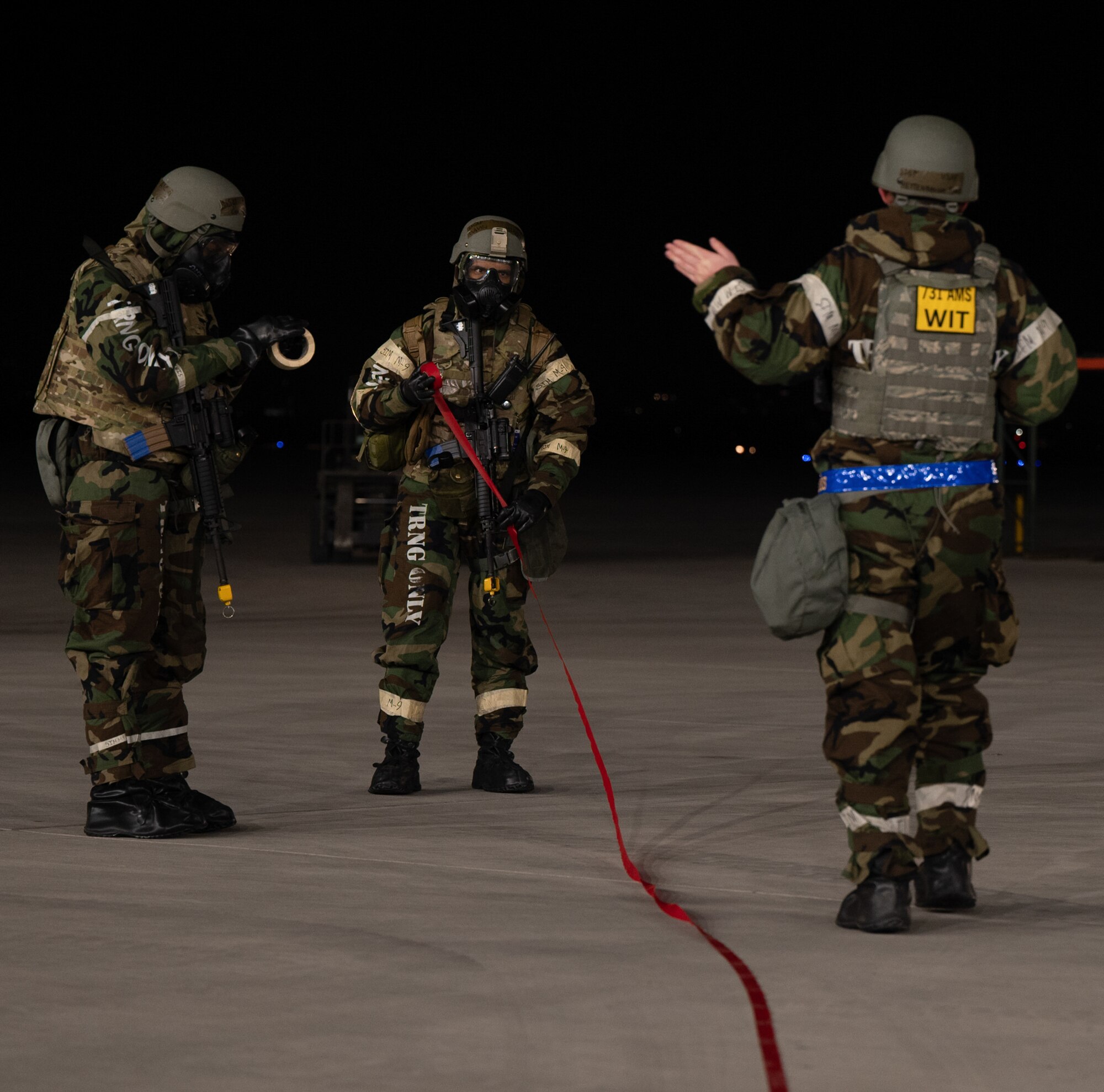 U.S. Air Force Staff Sgt. Ryan Hettenbaugh, 731st Air Mobility Squadron air traffic safety electronics personnel evaluator, right, evaluates simulated unexploded ordnance cordoning performed by Airman 1st Class Candace Yates, left, and Airman Gavyn Hinojosa, middle, 731st  AMC passenger service representatives, during Beverly Midnight 24-1 at Osan Air Base, Republic of Korea, Jan. 30, 2024. As the most forward deployed permanently based wing in the Air Force, the 51st Fighter Wing is charged with providing mission-ready Airmen to execute combat operations and receive follow-on forces. BM24-1 is a routine training event that tests the military capabilities across the peninsula, allowing combined and joint training at both the operational and tactical levels. (U.S. Air Force photo by Senior Airman Brittany Russell)