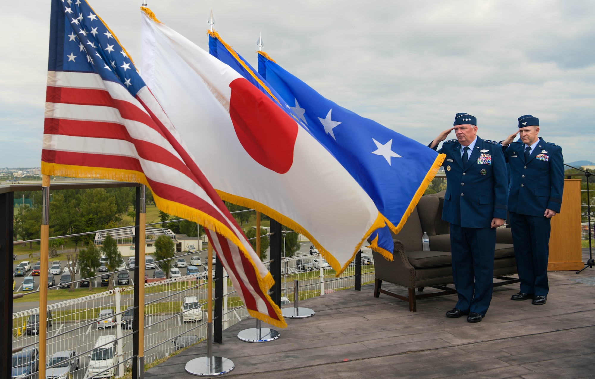 U.S. Air Force Lt. Gen. Ricky Rupp, left, U.S. Forces Japan and Fifth Air Force commander, and U.S. Air Force Brig. Gen. Nicholas Evans, right, 18th Wing commander, salute the U.S. flag during the singing of the U.S. national anthem.