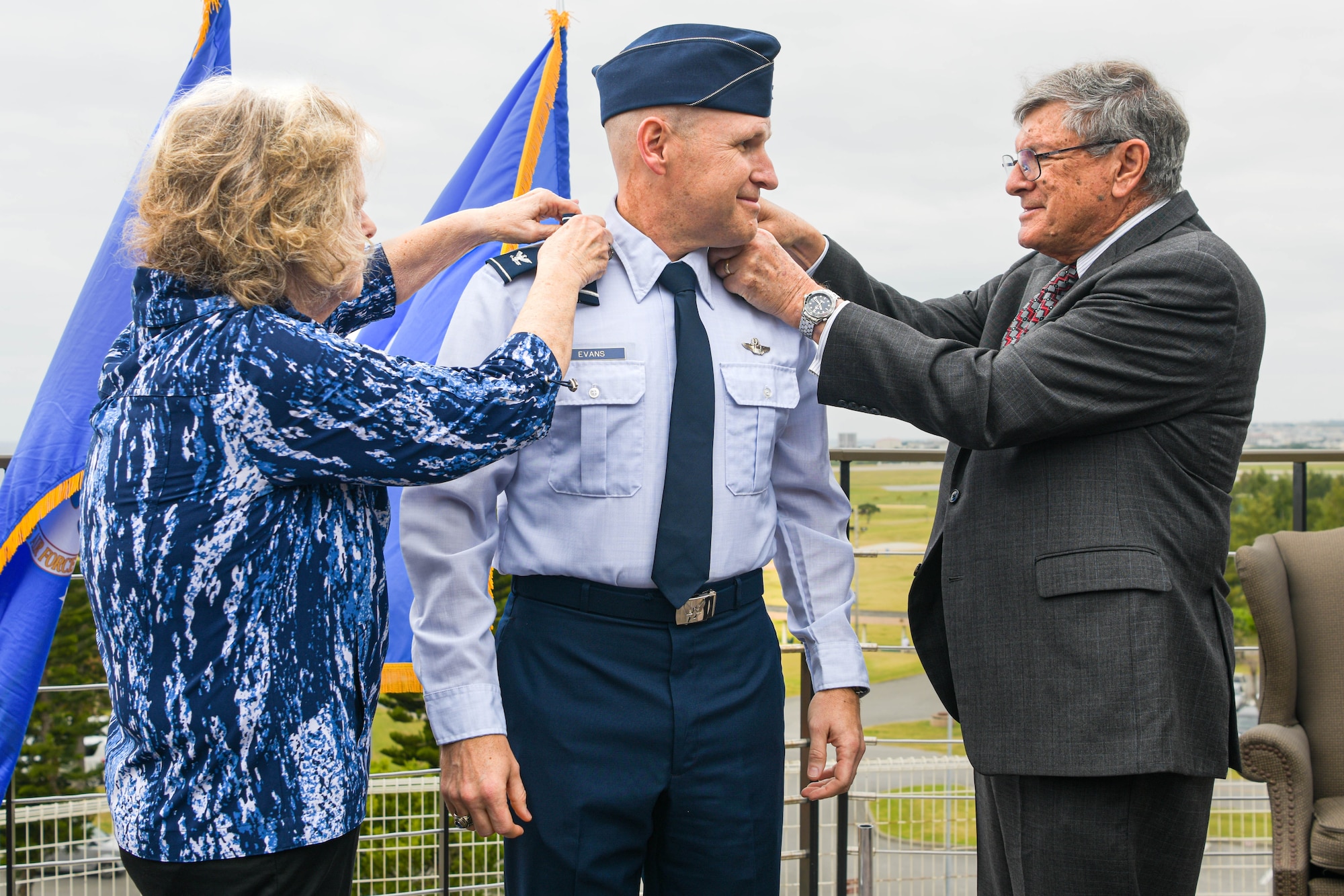 U.S. Air Force Brig. Gen. Nicholas Evans, center, 18th Wing commander, has his epaulets exchanged by his mother, Dorthy Evans, left, and his father, Jack Evans, right, during a promotion ceremony.