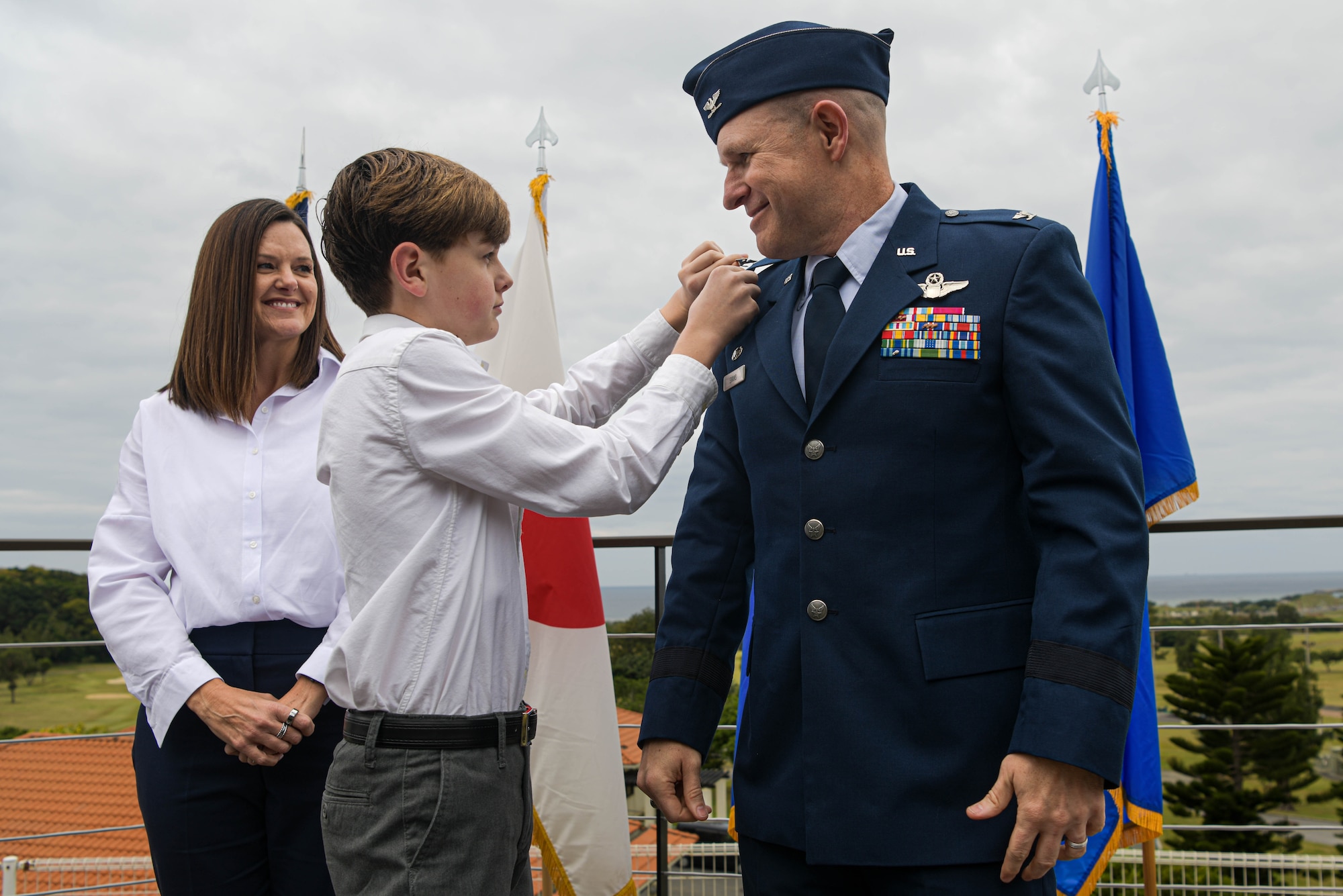 Nathan Evans, center, son of Brig. Gen. Nicholas Evans, right, 18th Wing commander, exchanges his father’s rank during a promotion ceremony.