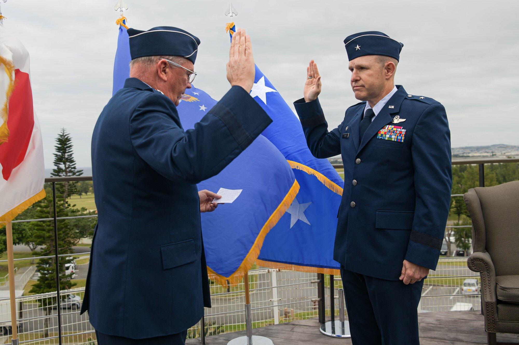 U.S. Air Force Lt. Gen. Ricky Rupp, left, U.S. Forces Japan and Fifth Air Force commander, leads U.S. Air Force Brig. Gen. Nicholas Evans, right, 18th Wing commander, in the oath of office during a promotion ceremony.