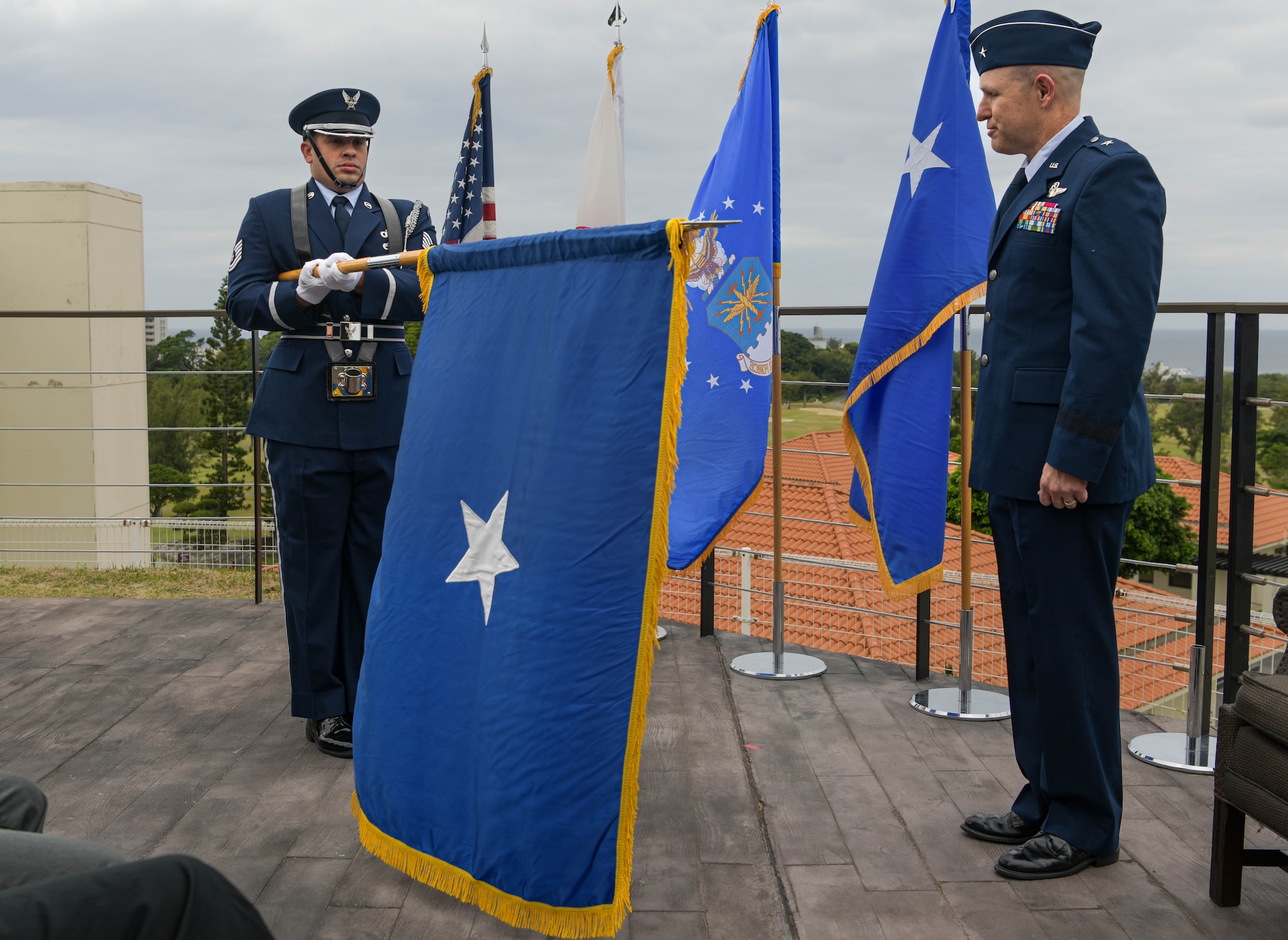 U.S. Air Force Tech. Sgt Julian Vanegas, Kadena Air Base Honor Guard, presents U.S. Air Force Brig. Gen. Nicholas Evans, 18th Wing commander, with a flag during a promotion ceremony.