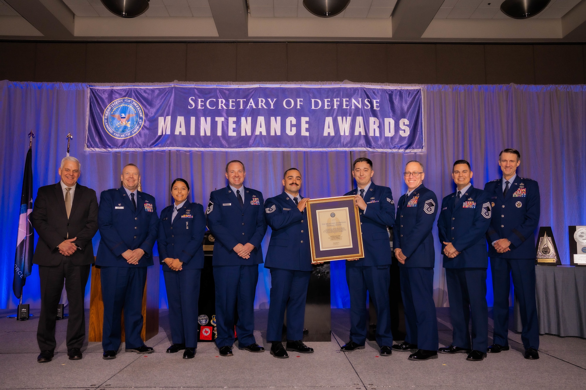 18th MXG winners stand with their award