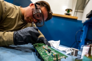 U.S. Air Force Senior Airman Joseph Besko, Avionics and Air Force Repair Enhancement Program technician, cleans a computer chip at an undisclosed location within the U.S. Central Command area of responsibility, Jan. 16, 2024. Specializing in repairing aircraft parts and extending its support to diverse equipment across squadrons, AFREP adaptability streamlines repair processes, reducing manpower hours and allowing skilled personnel to focus on complex tasks. (U.S. Air Force photo by Staff Sgt. Lawrence Sena)
