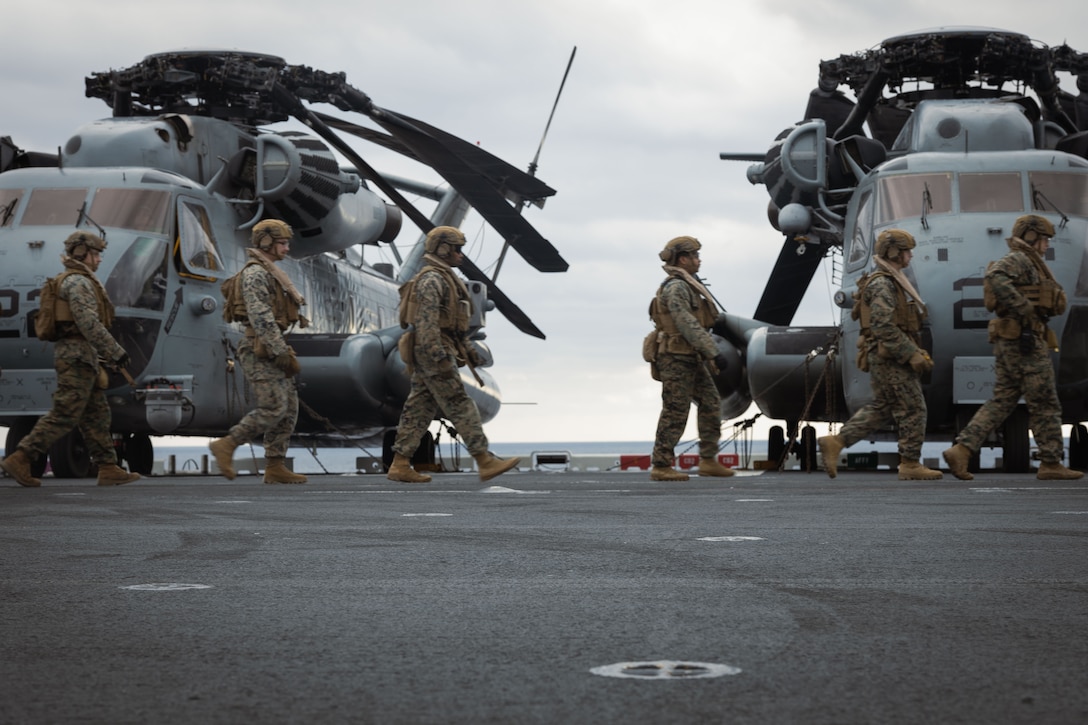 U.S. Marines with Battalion Landing Team 1/1, 31st Marine Expeditionary Unit, cross the flight deck of the amphibious assault ship USS America during a helicopter boarding drill in the Philippine Sea, Jan. 30, 2024. Boarding drills refine the Marines’ ability to board and offload helicopters quickly and efficiently during time critical mission sets. The 31st MEU is operating aboard ships of the America Amphibious Ready Group in the 7th Fleet area of operations to enhance interoperability with allies and partners and serve as a ready response force to defend peace and stability in the Indo-Pacific region.