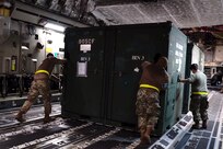 A photo of Airmen pushing cargo.