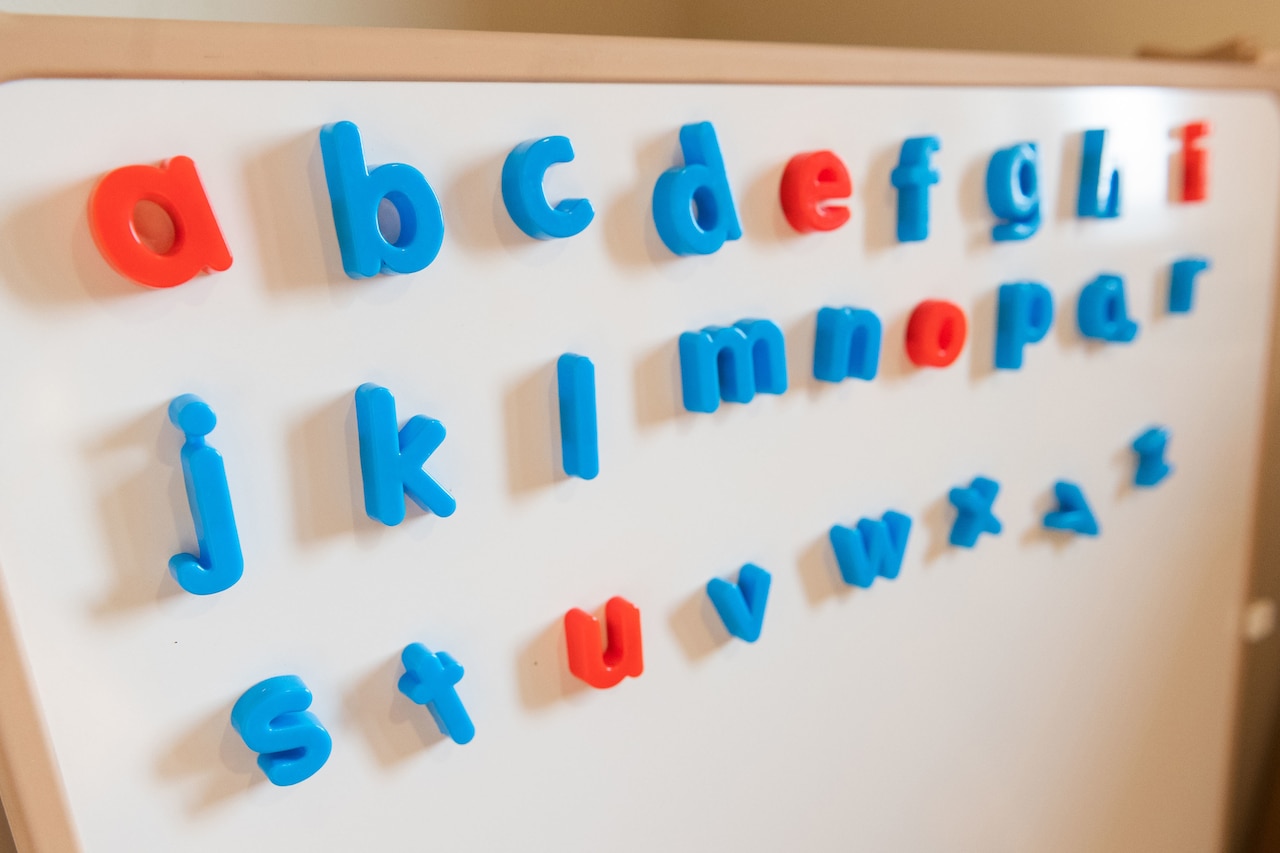 A board displaying magnetic letters is photographed.