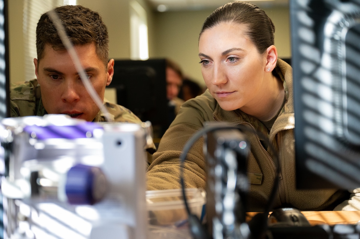 U.S. Air Force Maj. John Gayk and Tech. Sgt. Lauren Davis prepare their IV pump settings at the Baptist South Simulation Lab in Montgomery, Ala., Jan. 18, 2024. 42nd Medical Group personnel trained on IV pump settings to dispense fluids from the primary channel.