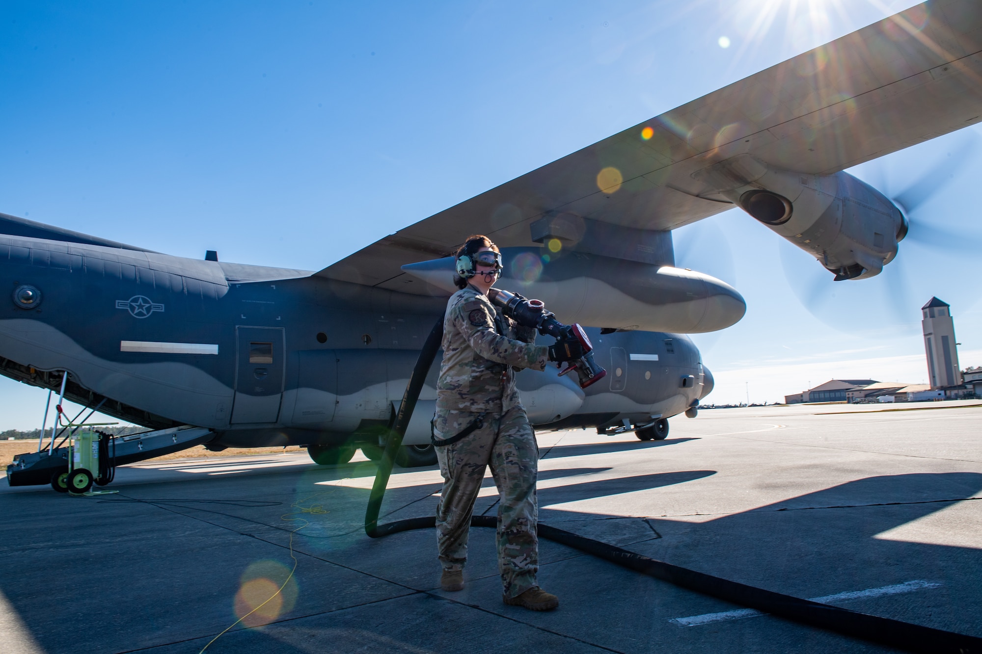 Airman carries fuel hose
