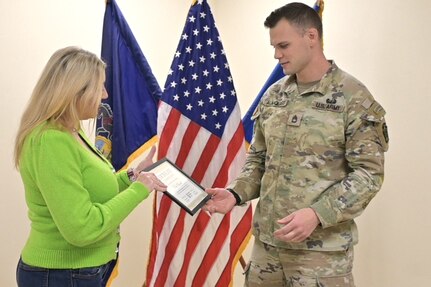 Sgt. 1st Class Paul Almquist, a range operations noncommissioned officer with the Fort Indiantown Gap Training Center, receives an award for his volunteer work with Big Brothers Big Sisters of the Capital Region during a ceremony at Fort Indiantown Gap, Pennsylvania, Jan. 30, 2024. Almquist has volunteered with that organization for eight years, impacting children’s lives. Deborah Wright, director of Lebanon and Lancaster counties presented the award on behalf of Big Brothers Big Sisters. (U.S. Army National Guard photo by 2nd Lt. Kate Kramer)