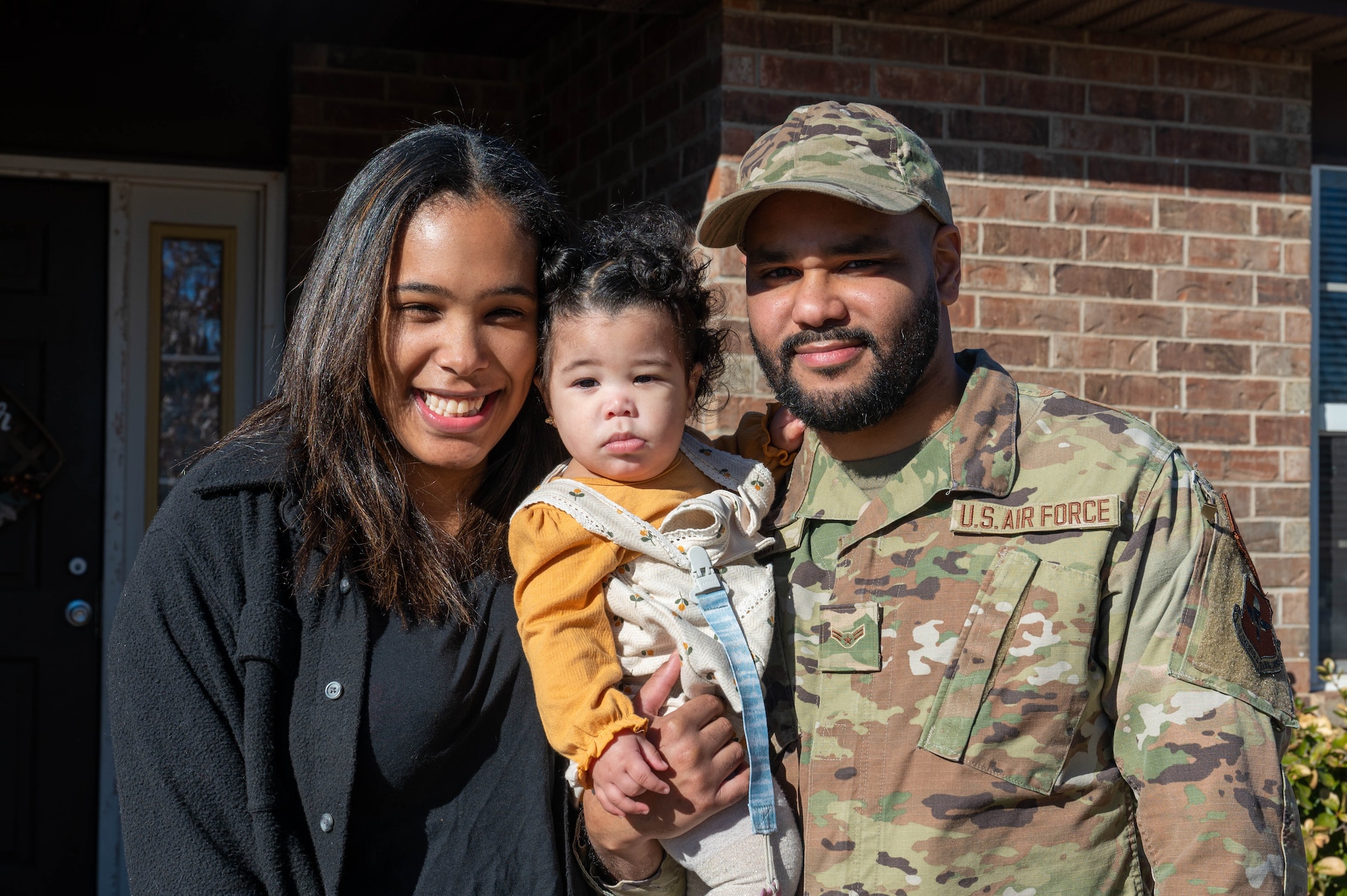 Roisveli Matos, Family Child Care (FCC) provider, and U.S. Air Force Airman 1st Class Micheal Paula, 97th Operations Support Squadron radar airfield weather systems journeyman, pose for a photo with their child during a ribbon-cutting ceremony at Altus Air Force Base, Oklahoma, Jan. 29, 2024. Matos was inspired to follow in her mother’s footsteps by opening her own in-home daycare. (U.S. Air Force photo by Airman 1st Class Heidi Bucins)