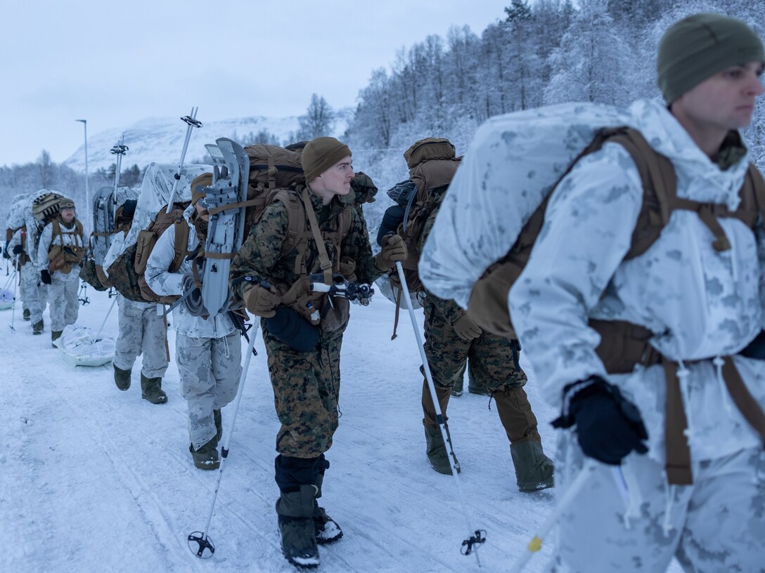 Marines hike in the snow.