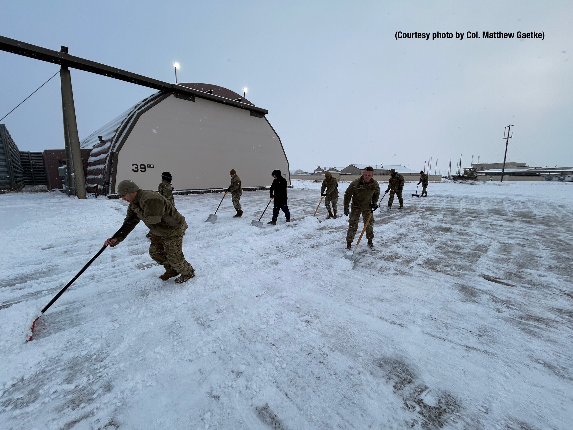 Airmen shoveling snow.