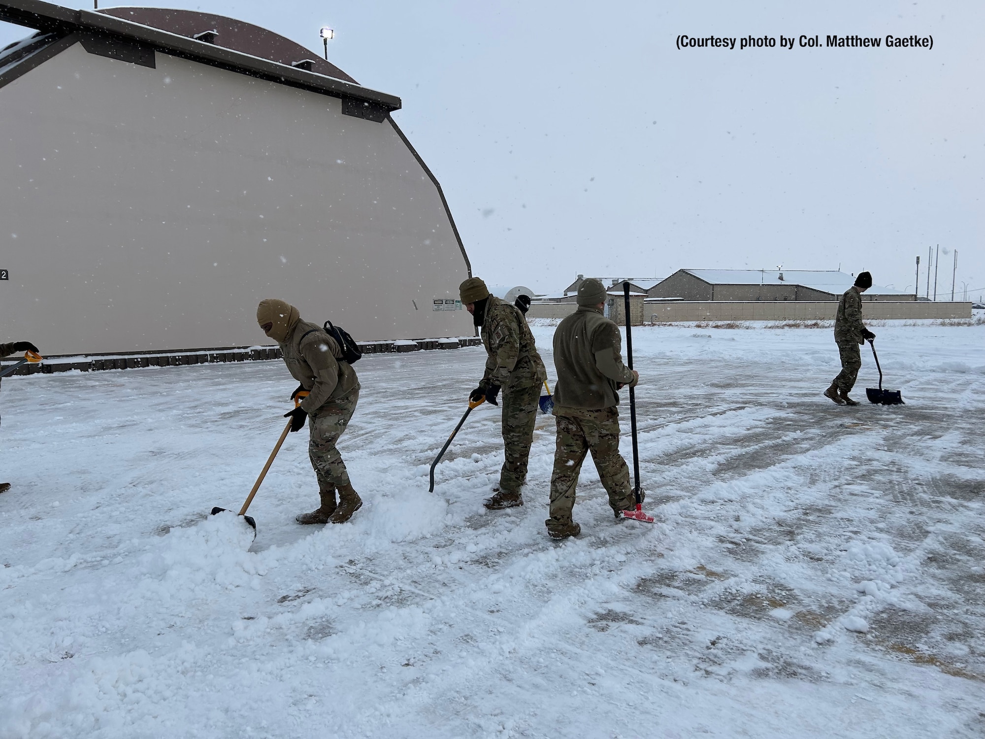 Airmen shoveling snow.
