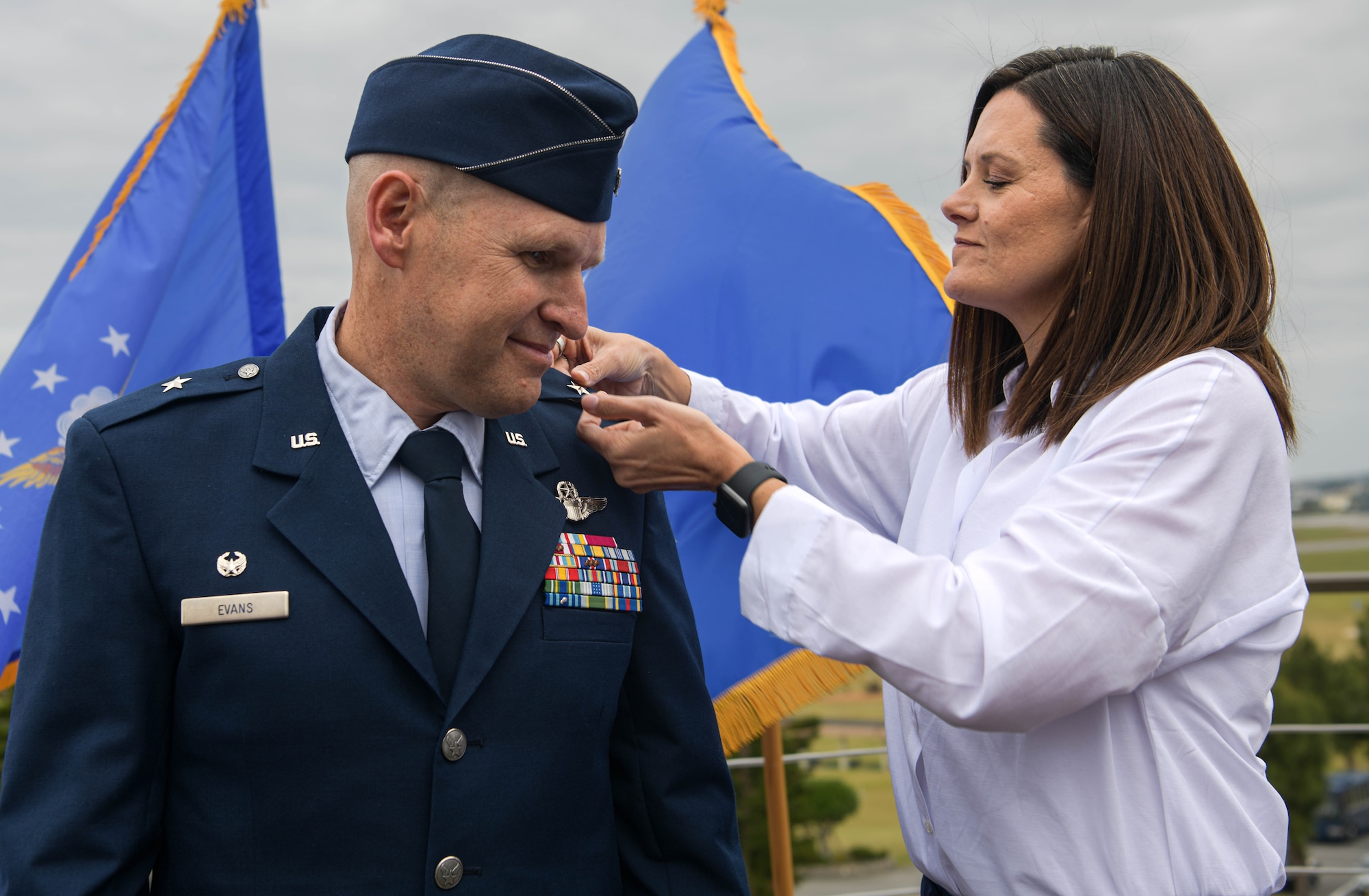 Shelley Evans, right, pins on the rank of her husband, U.S. Air Force Brig. Gen. Nicholas Evans, left, 18th Wing commander, during a promotion ceremony.