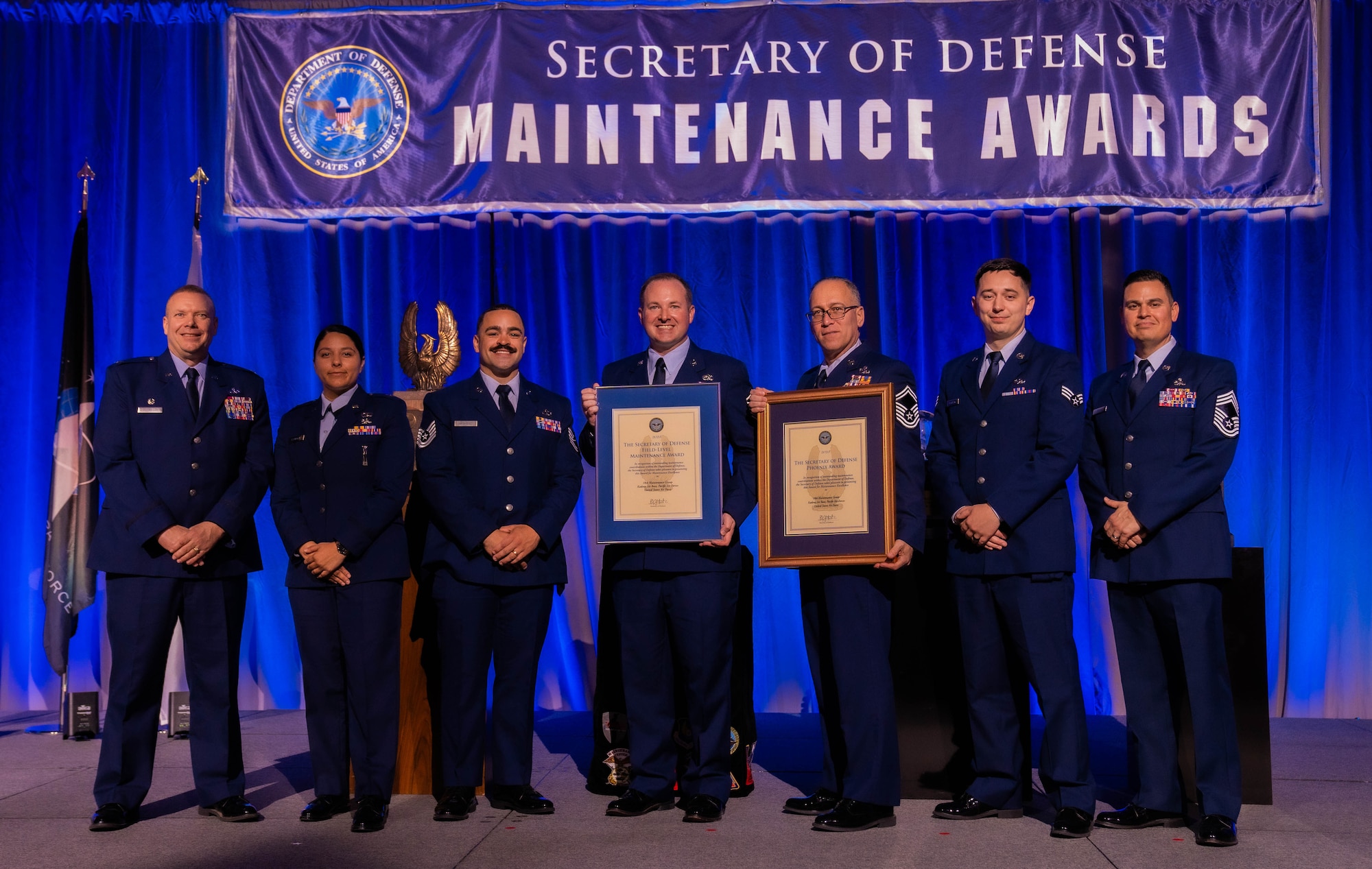18th MXG winners stand with their award