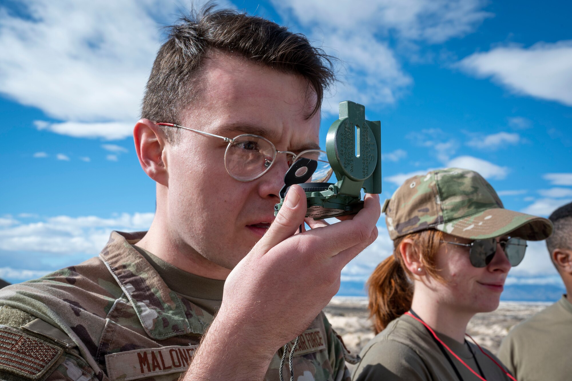 U.S. Air Force Airman 1st Class Joseph Maloney, 54th Operations Support Squadron weather journeyman, uses a compass to chart the surrounding area during an exercise at Holloman Air Force Base, New Mexico, Jan. 22, 2024. The 54th OSS gives updates on weather conditions and mission locations for both Holloman and occasionally the White Sands Missile Range. (U.S Air Force photo by Airman 1st Class Isaiah Pedrazzini)