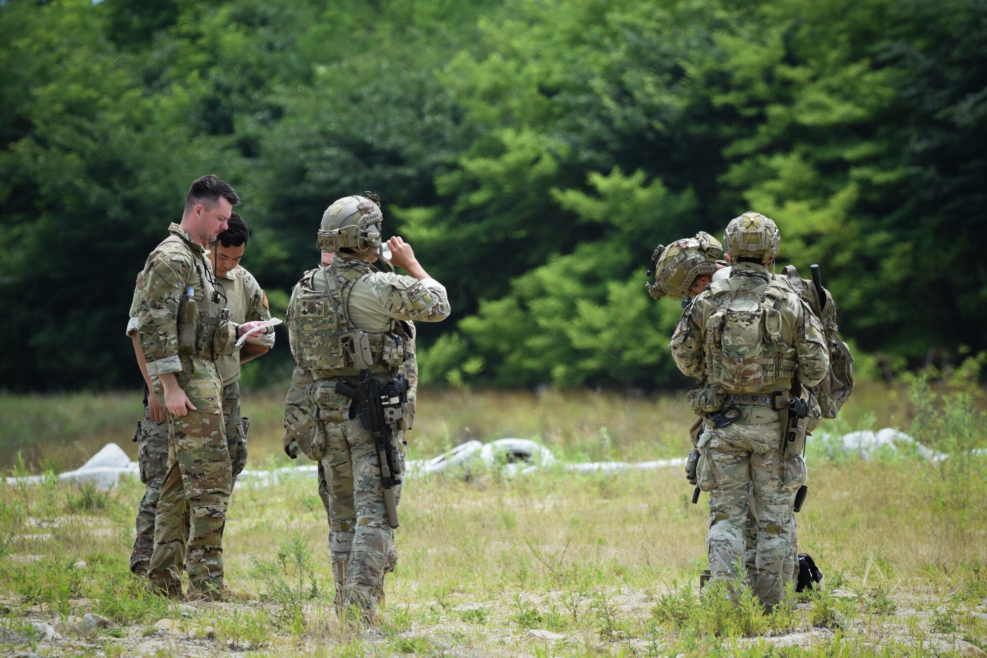 U.S. Air Force Capt. George Foggin, left, air mobility liaison officer for the 607th Air Support Operations Group, coordinates with Republic of Korea combat controllers during a combined Republic of Korea and U.S. cargo drop training event near Yeoju, Republic of Korea.