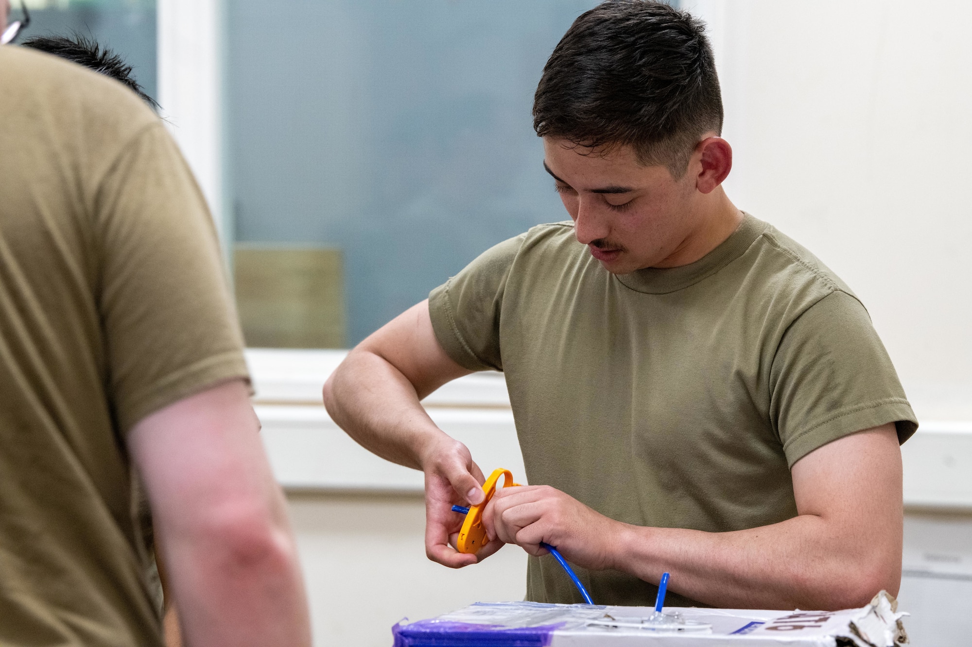 An Airman strips a category 6 cable during a Tiger Challenge