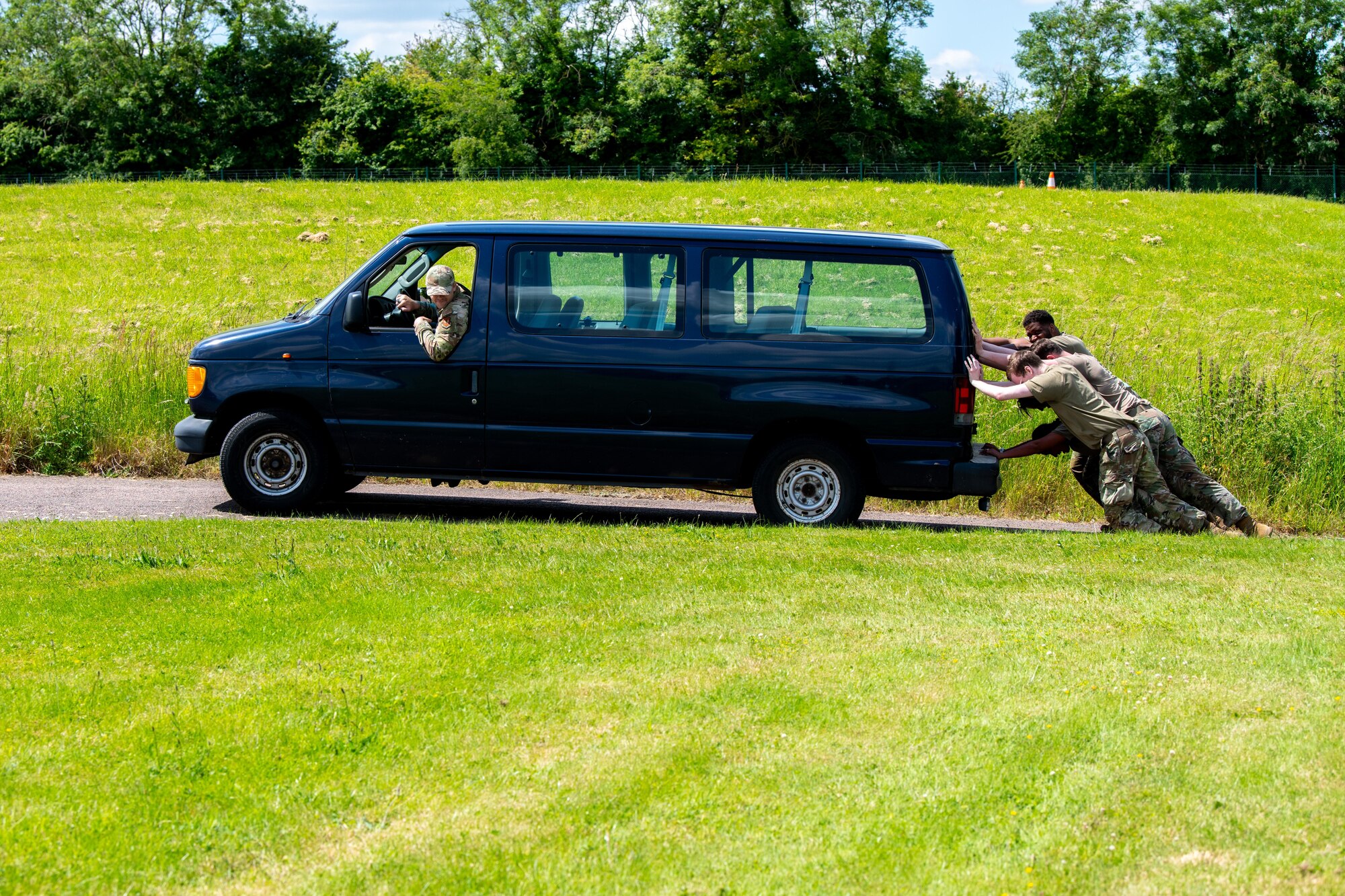 Airmen push a van