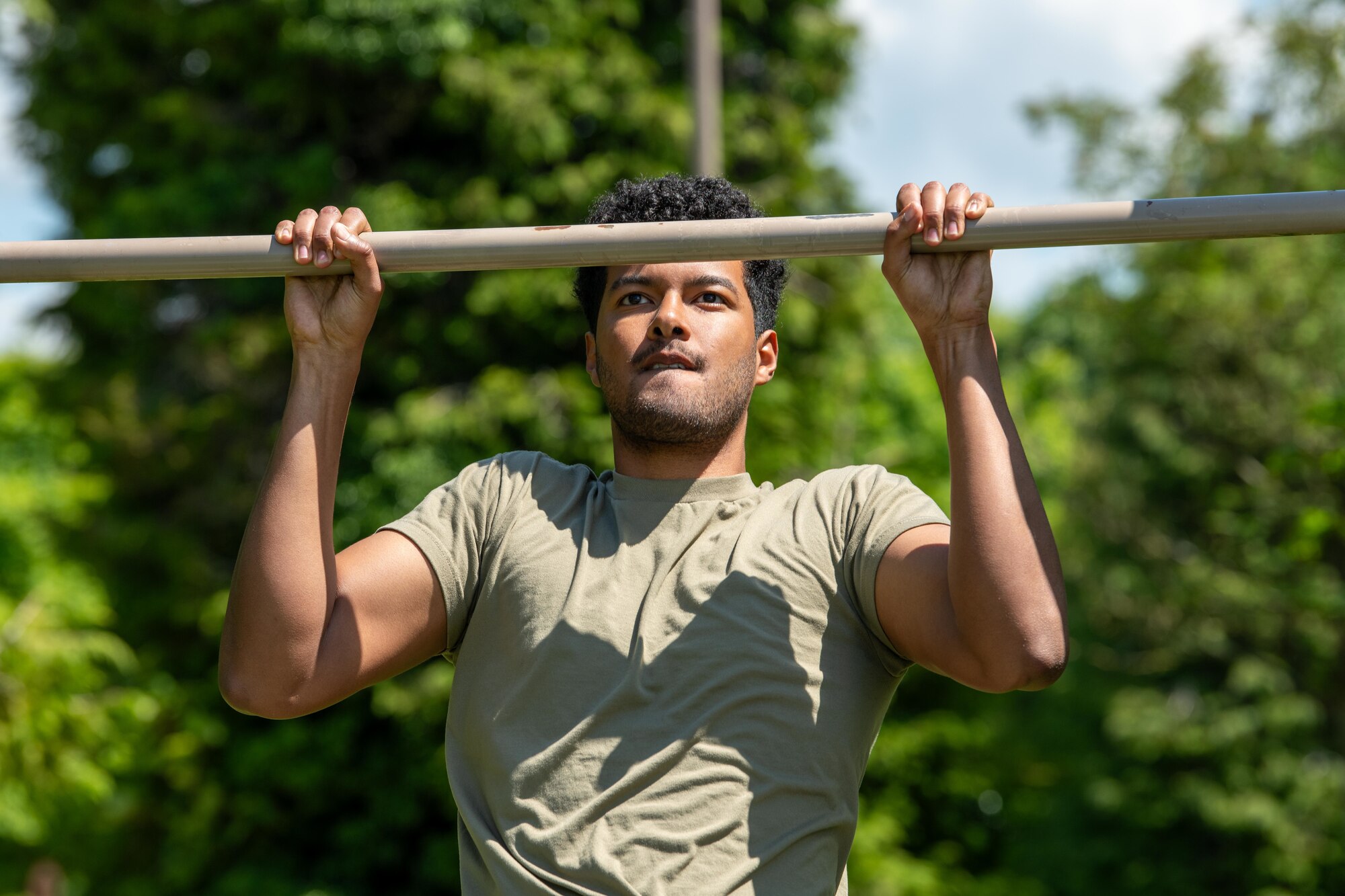 An Airman performs pull ups