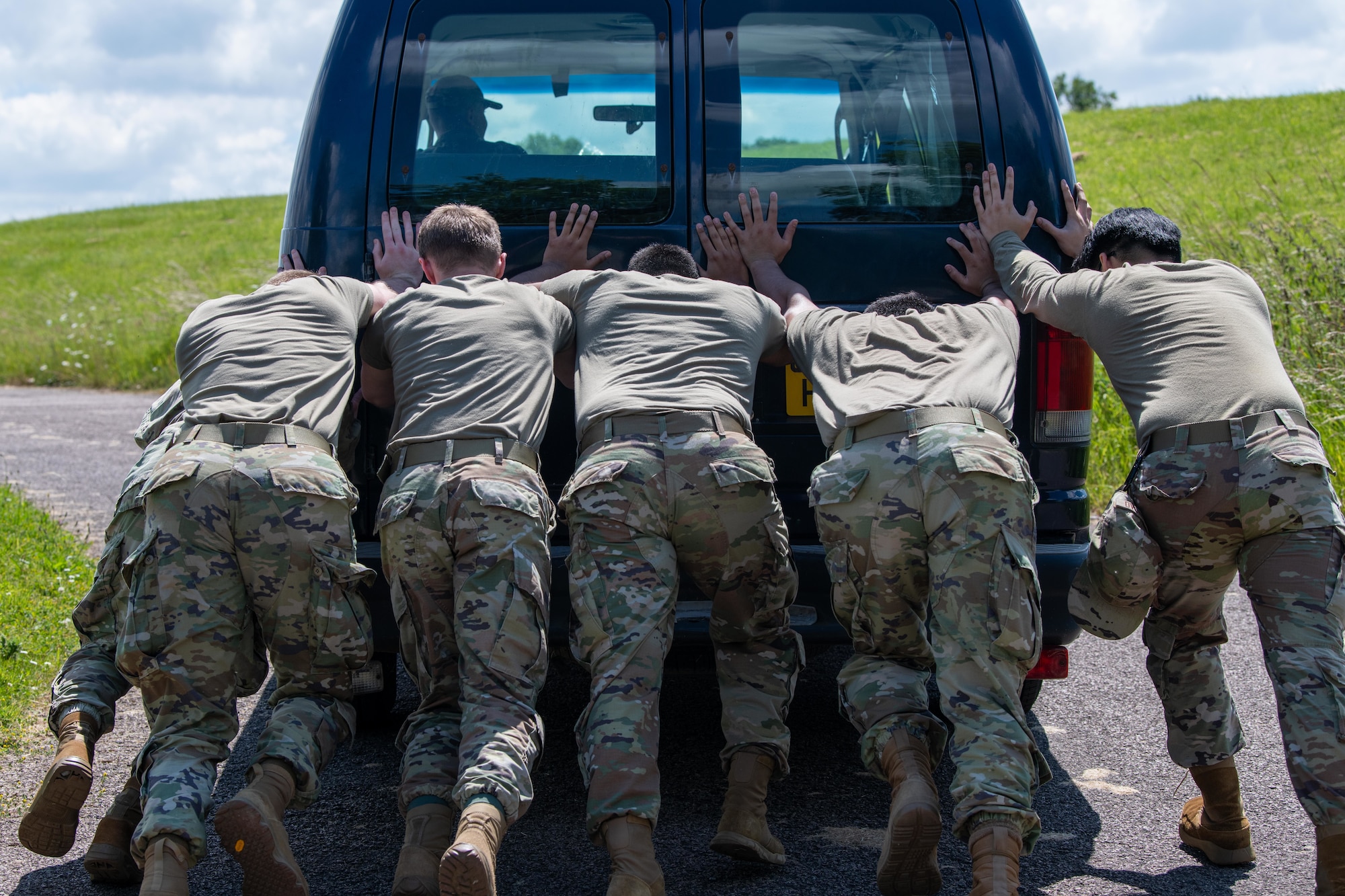 Airmen push a van