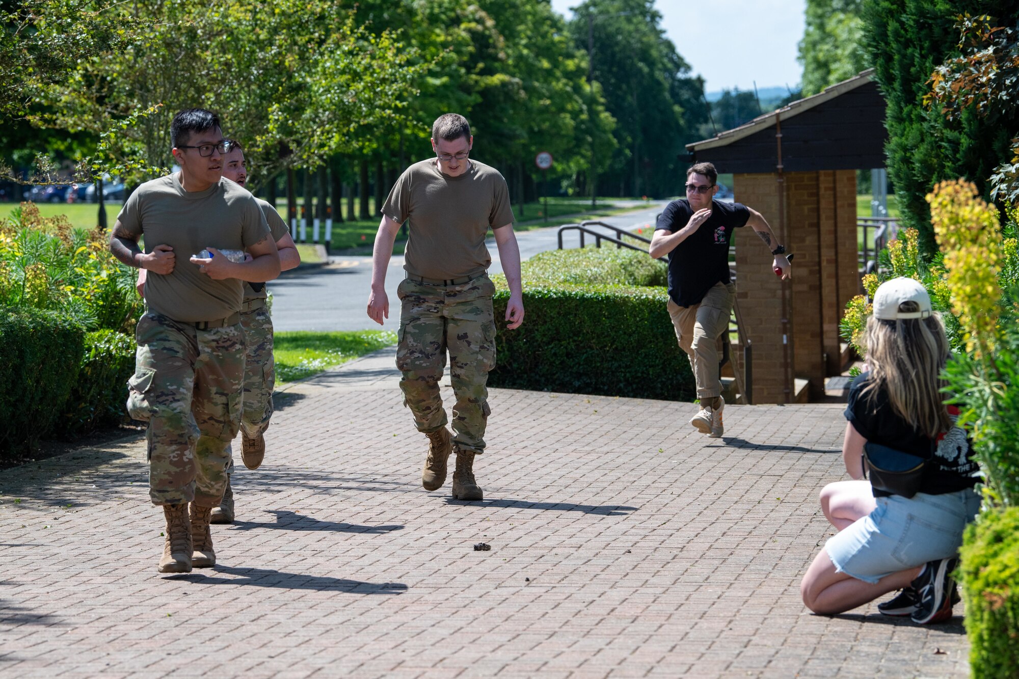 An Airman runs towards others during a simulated attack