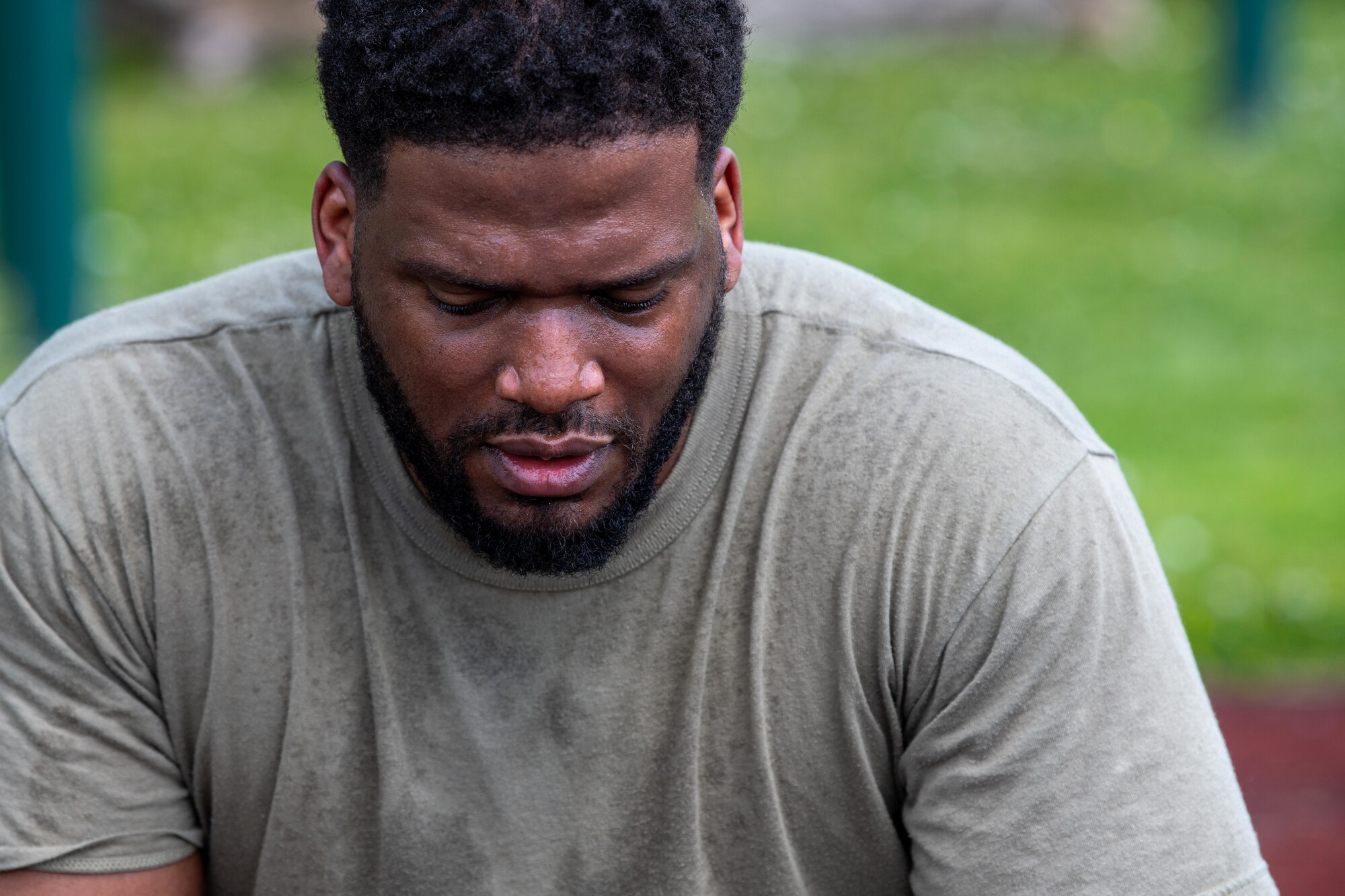 An Airman looks down while sweating