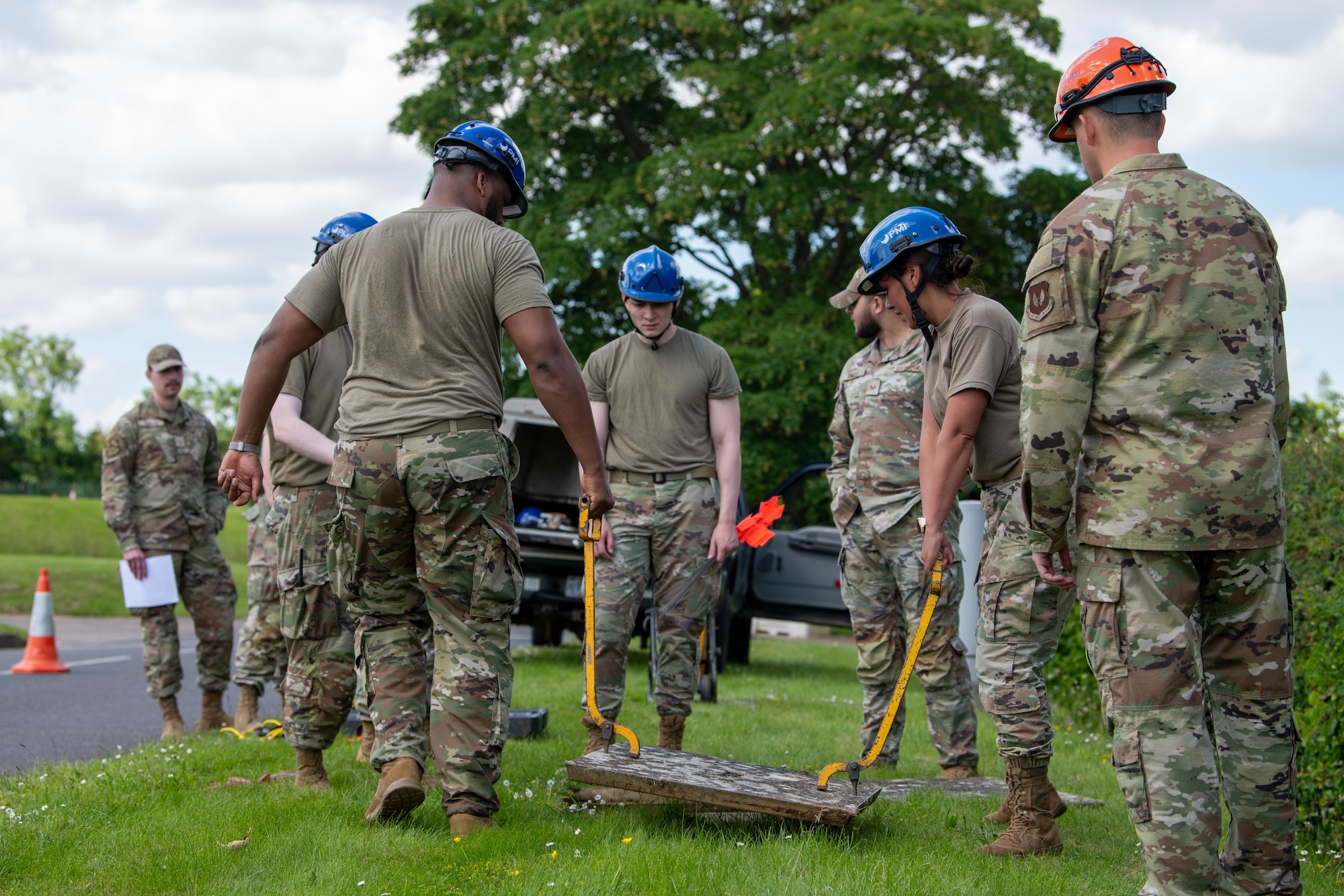 Airmen lift a manhole cover during a Tiger Challenge