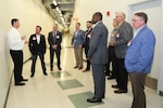 Men standing in hallway during tour.
