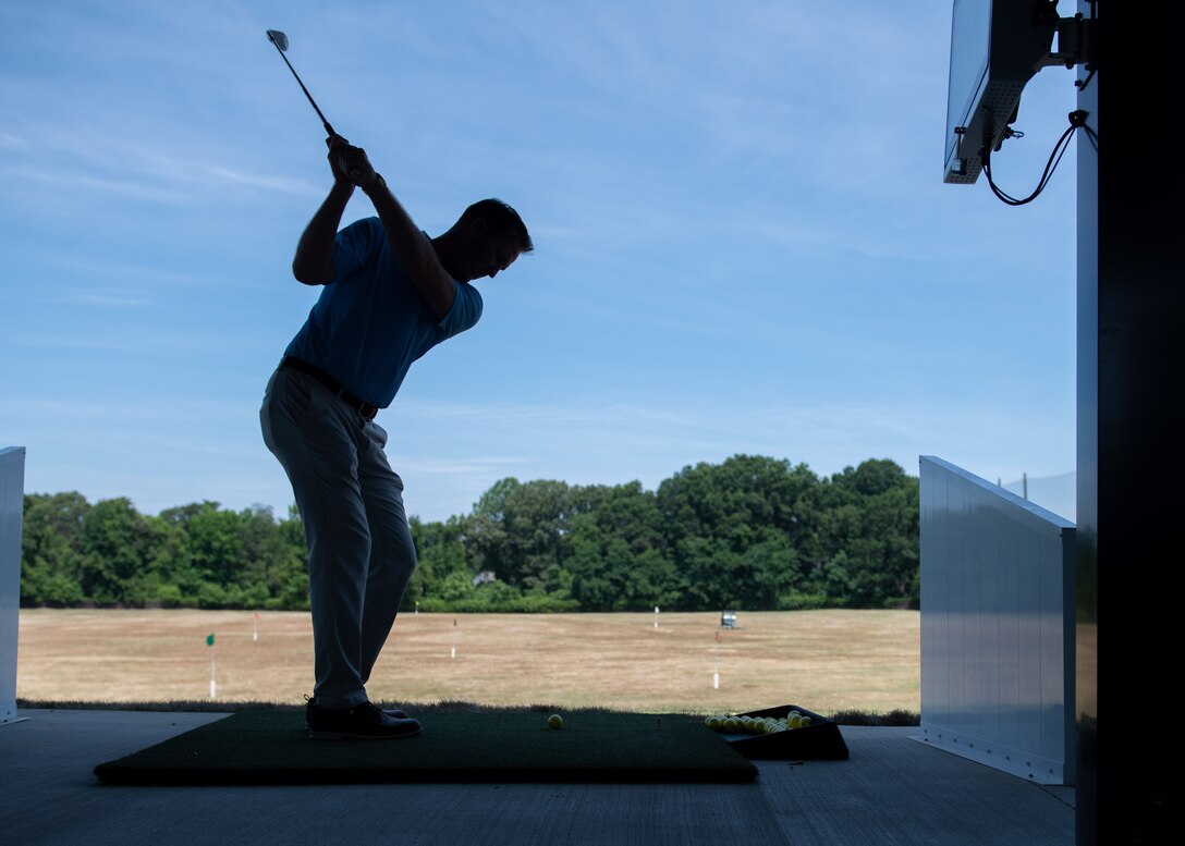 Individual hitting a golf ball.