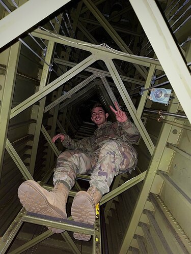 An Airman strikes a pose while making the 65-foot climb up the inside of a C-5 tail. (U.S. Air Force photo)