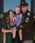 Man wearing Army uniform standing with his family