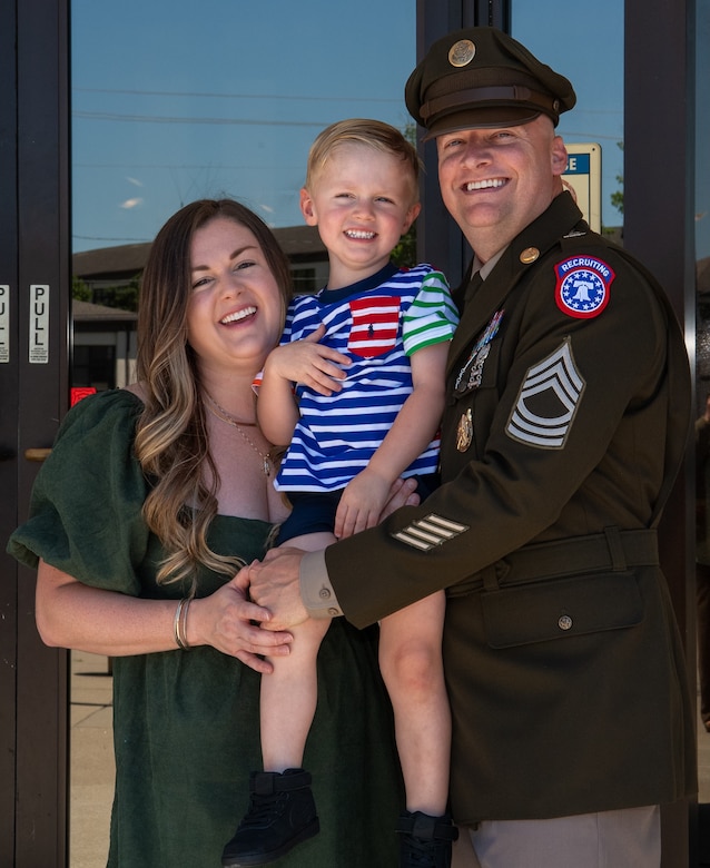 Man wearing Army uniform standing with his family
