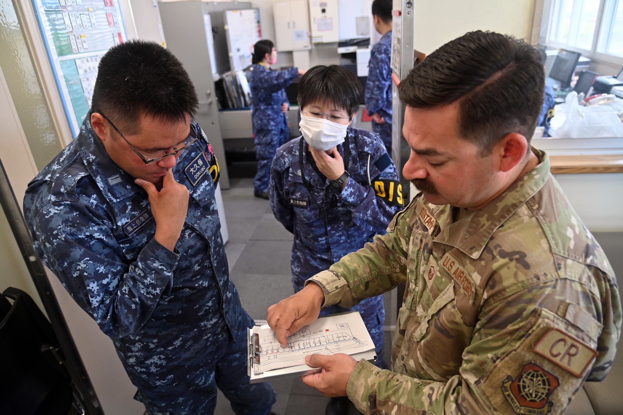 Members from the 721st Contingency Response Squadron and the Japan Maritime Self-Defense Force discuss the parking plan for the incoming F-16s during Exercise Valiant Shield at Japan Maritime Self-Defense Force Hachinohe Air Base, June 11, 2024.