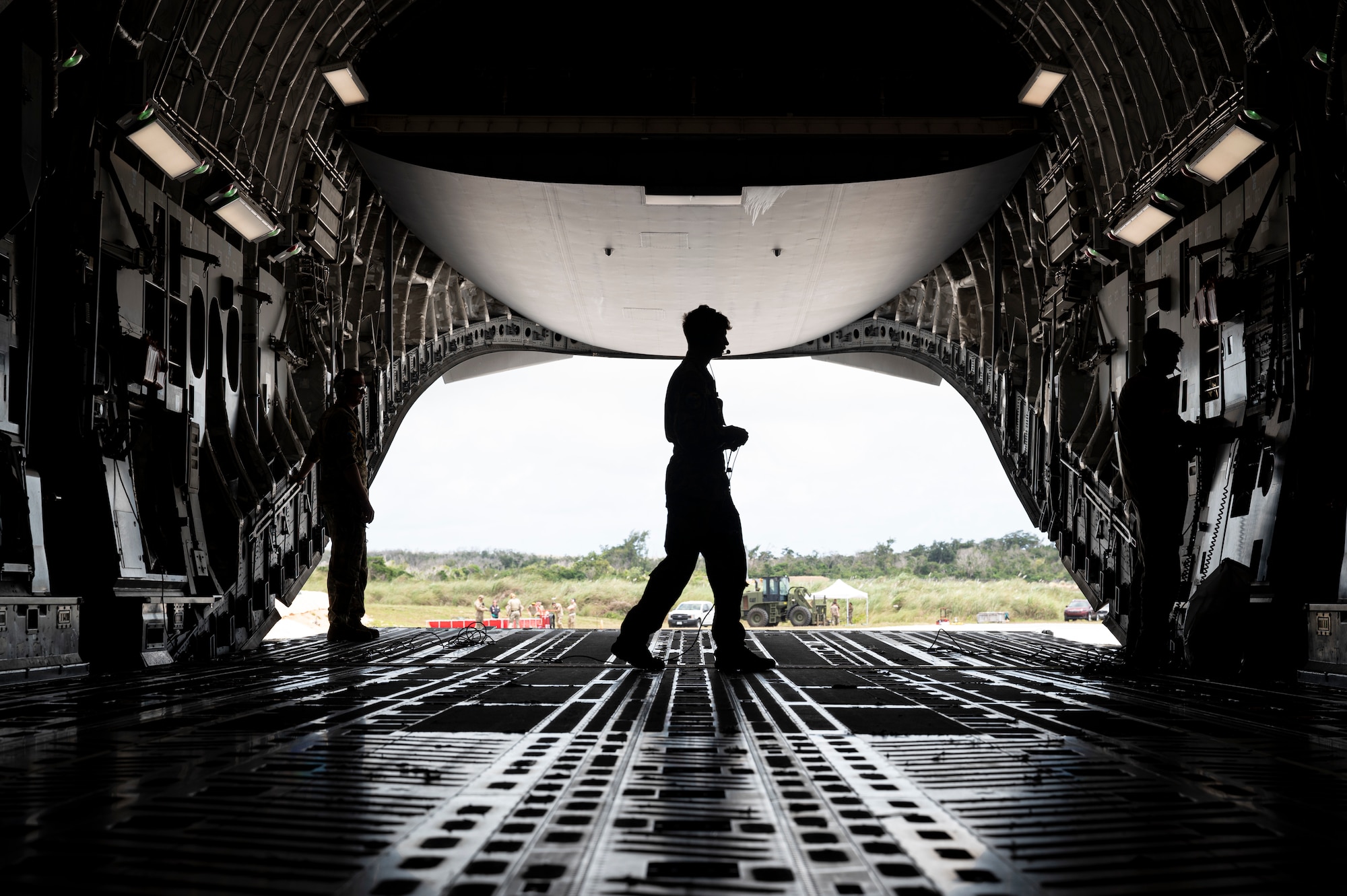 U.S. Air Force Senior Airman Ian Allen, 305th Aircraft Maintenance Squadron (AMXS) flying crew chief, left, Airman 1st Class Logan Long, middle, and Senior Airman Braden Russel, right, 6th Airlift Squadron (AS) loadmasters, lower the ramp on a U.S. Air Force C-17 Globemaster III at an auxiliary field near Anderson Air Force Base, Guam in support of Valiant Shield 2024 June 10, 2024. Specialized fueling operations increase flexibility for mobility aircraft to maneuver the joint force. Exercises such as Valiant Shield allow the Indo-Pacific Command Joint Forces the opportunity to integrate forces from all branches of service and with our allies to conduct precise, lethal, and overwhelming multi-axis, multi-domain effects that demonstrate the strength and versatility of the Joint Force and our commitment to a free and open Indo-Pacific. (U.S. Air Force photo by Senior Airman Keegan Putman)