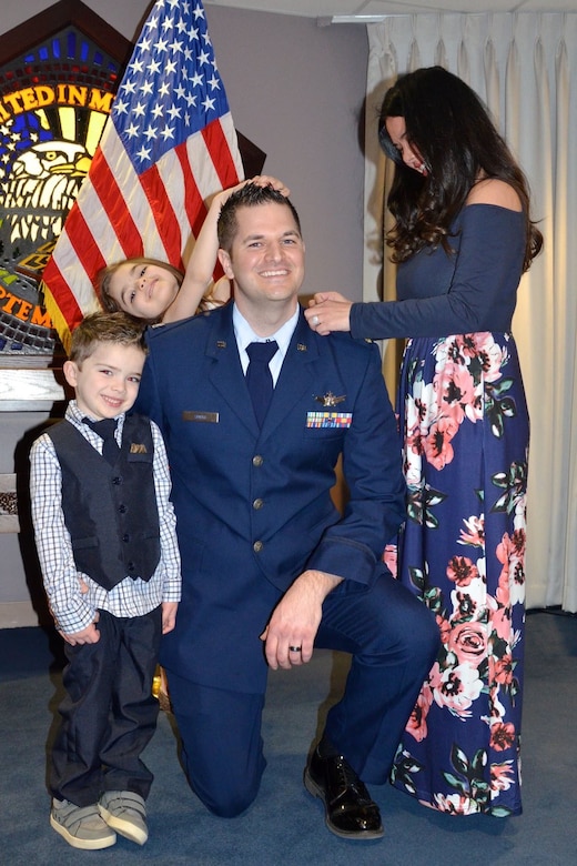 A military officer smiles while being promoted.