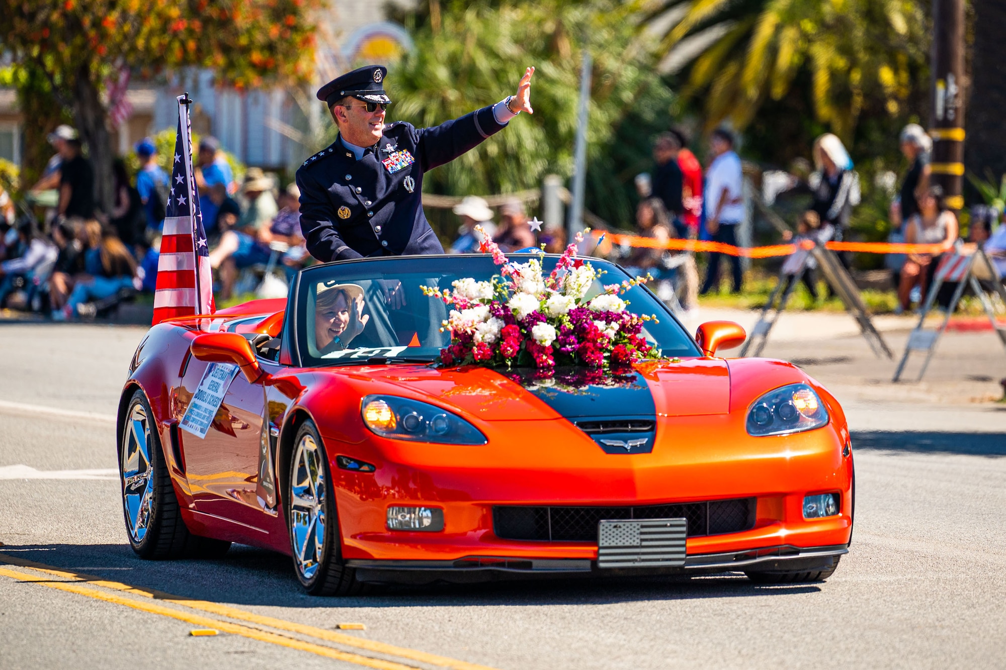 U.S. Space Force Lt. Gen. Douglas A. Schiess, U.S. Space Forces - Space commander and the Combined Joint Force Space Component Commander, and his wife Debbie, wave to the crowd during the Lompoc Flower Festival Parade in Lompoc, Calif., June 22, 2024. Leadership from U.S. Space Forces - Space and Space Launch Delta 30 participated in the parade which had over 50 entrees and 500 attendees. (U.S. Space Force photo by Tech. Sgt. Luke Kitterman)