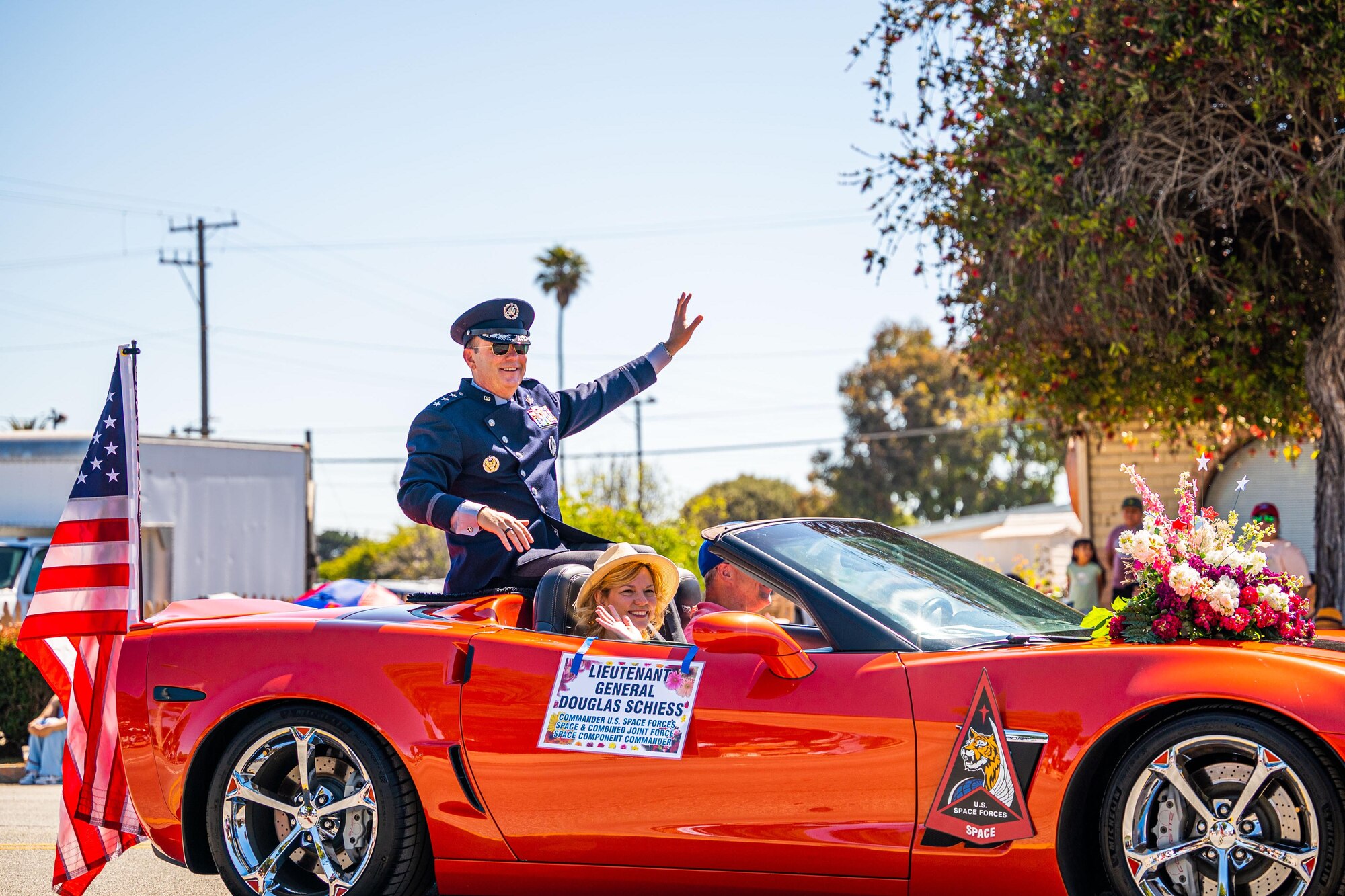 U.S. Space Force Lt. Gen. Douglas A. Schiess, U.S. Space Forces - Space commander and the Combined Joint Force Space Component Commander, and his wife Debbie, wave to the crowd during the Lompoc Flower Festival Parade in Lompoc, Calif., June 22, 2024. Leadership from U.S. Space Forces - Space and Space Launch Delta 30 participated in the parade which had over 50 entrees and 500 attendees. (U.S. Space Force photo by Tech. Sgt. Luke Kitterman)