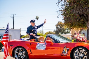 U.S. Space Force Lt. Gen. Douglas A. Schiess, U.S. Space Forces - Space commander and the Combined Joint Force Space Component Commander, and his wife Debbie, wave to the crowd during the Lompoc Flower Festival Parade in Lompoc, Calif., June 22, 2024. Leadership from U.S. Space Forces - Space and Space Launch Delta 30 participated in the parade which had over 50 entrees and 500 attendees. (U.S. Space Force photo by Tech. Sgt. Luke Kitterman)