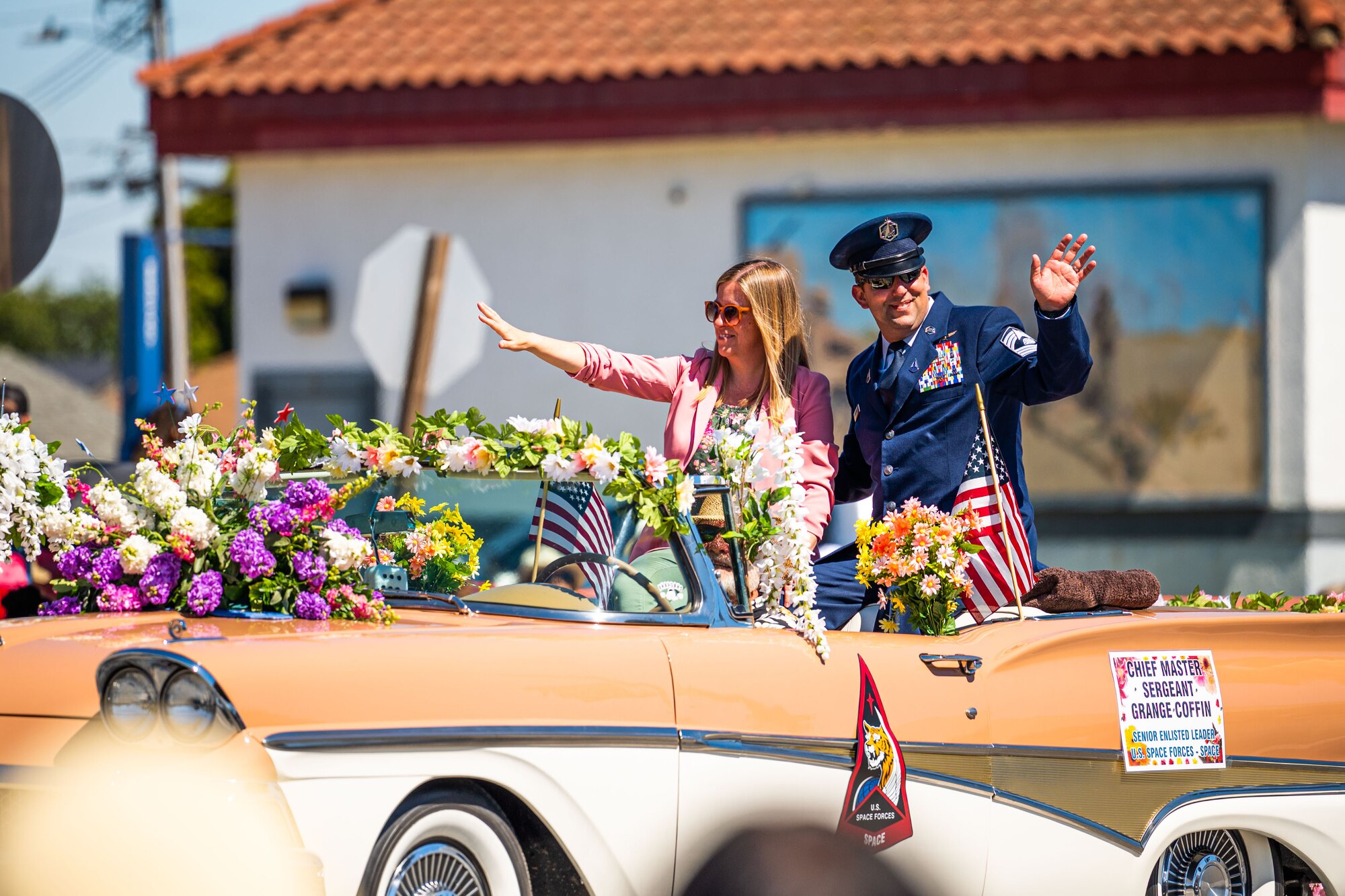 U.S. Space Force Chief Master Sgt. Grange S. Coffin, U.S. Space Forces - Space command senior enlisted leader, and his wife wave to the crowd during the Lompoc Flower Festival Parade in Lompoc, Calif., June 22, 2024. Leadership from U.S. Space Forces - Space and Space Launch Delta 30 participated in the parade which had over 50 entrees and 500 attendees. (U.S. Space Force photo by Tech. Sgt. Luke Kitterman)