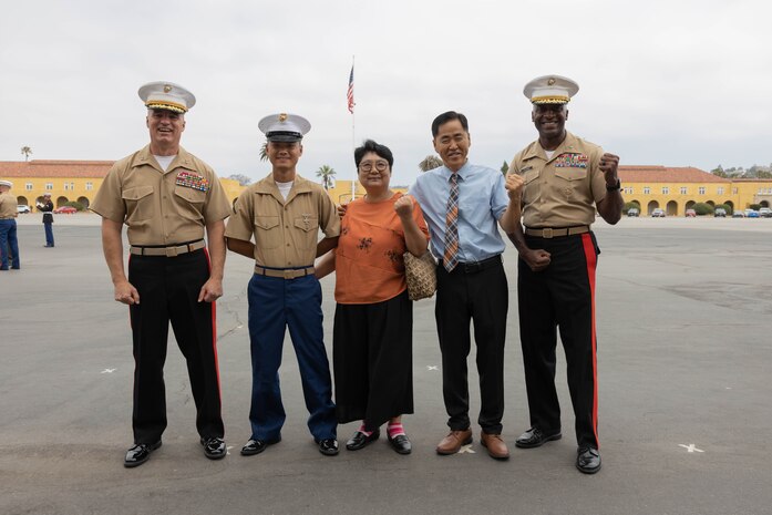U.S. Marine Corps Maj. Gen William E. Souza III, commanding general, U.S. Marine Corps Forces Korea, left, and Brig. Gen. James A. Ryans II, commanding general, Marine Corps Recruit Depot San Diego and Western Recruiting Region, right, pose for a picture with Pfc. Junyoung Kim, left center and his family after a graduation ceremony for Echo Company, 2nd Recruit Training Battalion at Marine Corps Recruit Depot San Diego, California, June 28, 2024. Kim is a native of South Korea and was one of seven Marines with Echo Company who became U.S. citizens. Kim was recruited from Granada Hills, California. Graduation took place at the completion of the 13-week transformation, which included training for drill, marksmanship, basic combat skills, and Marine Corps customs and traditions.  (U.S. Marine Corps photo by Lance Cpl. Alexandra M. Earl)