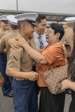 U.S. Marine Corps Pfc. Junyoung Kim with Echo Company, 2nd Recruit Training Battalion, greets his family after a graduation ceremony at Marine Corps Recruit Depot San Diego, California, June 28, 2024. Kim is a native of South Korea and was one of seven Marines with Echo Company who became U.S. citizens. Kim was recruited from Granada Hills, California. Graduation took place at the completion of the 13-week transformation, which included training for drill, marksmanship, basic combat skills, and Marine Corps customs and traditions. (U.S. Marine Corps photo by Lance Cpl. Alexandra M. Earl)